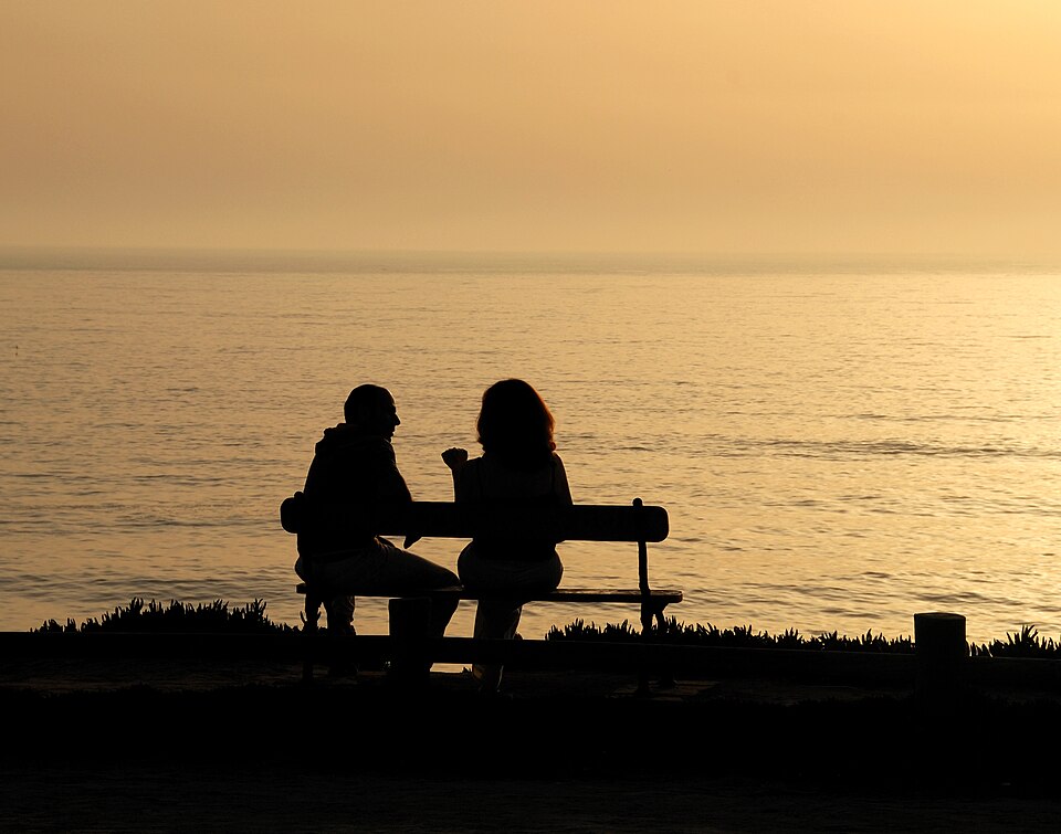 Duas pessoas conversando frente a frente em ambiente tranquilo